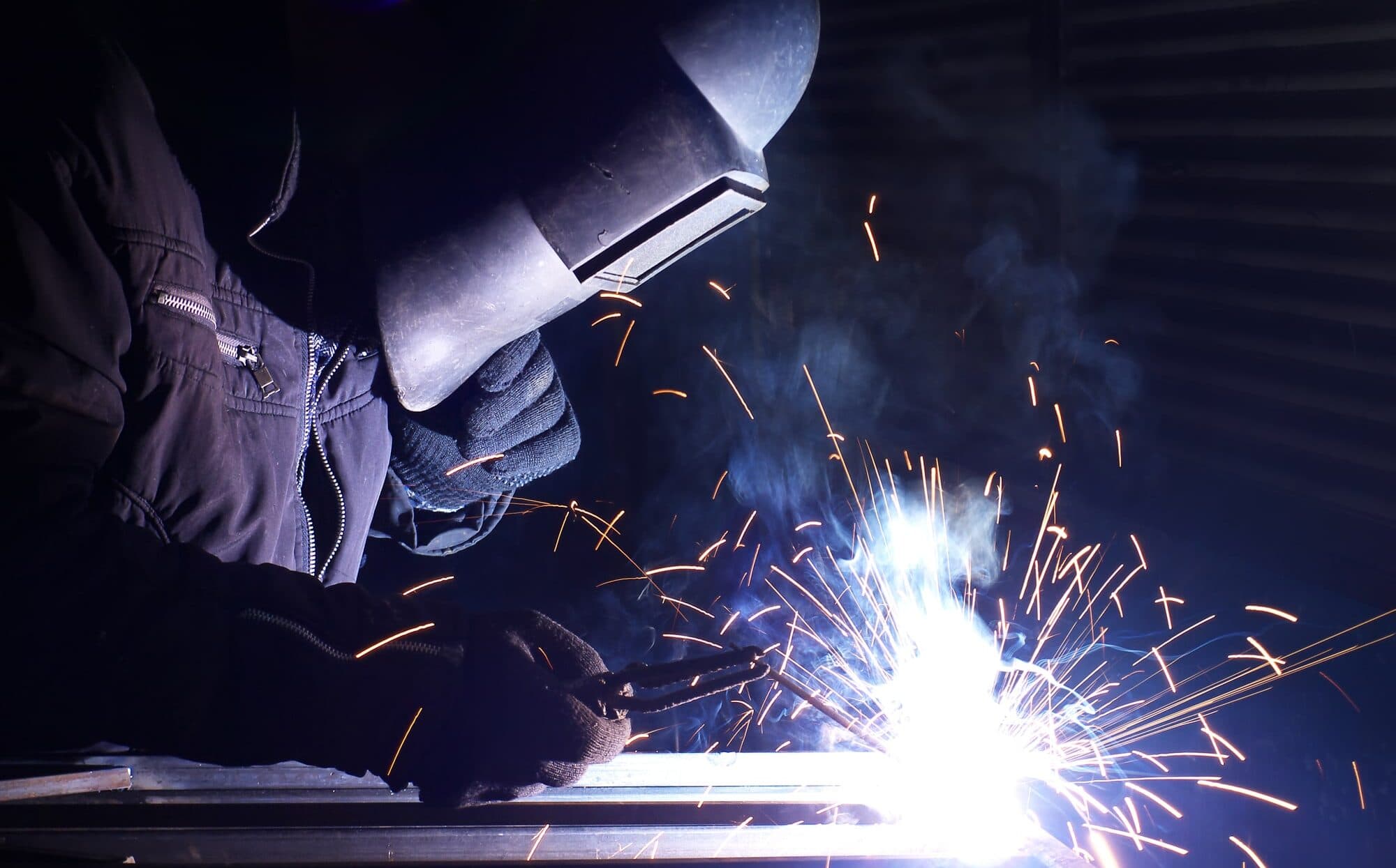 Welder repairing steel framework at a Precision Construction Repair job site